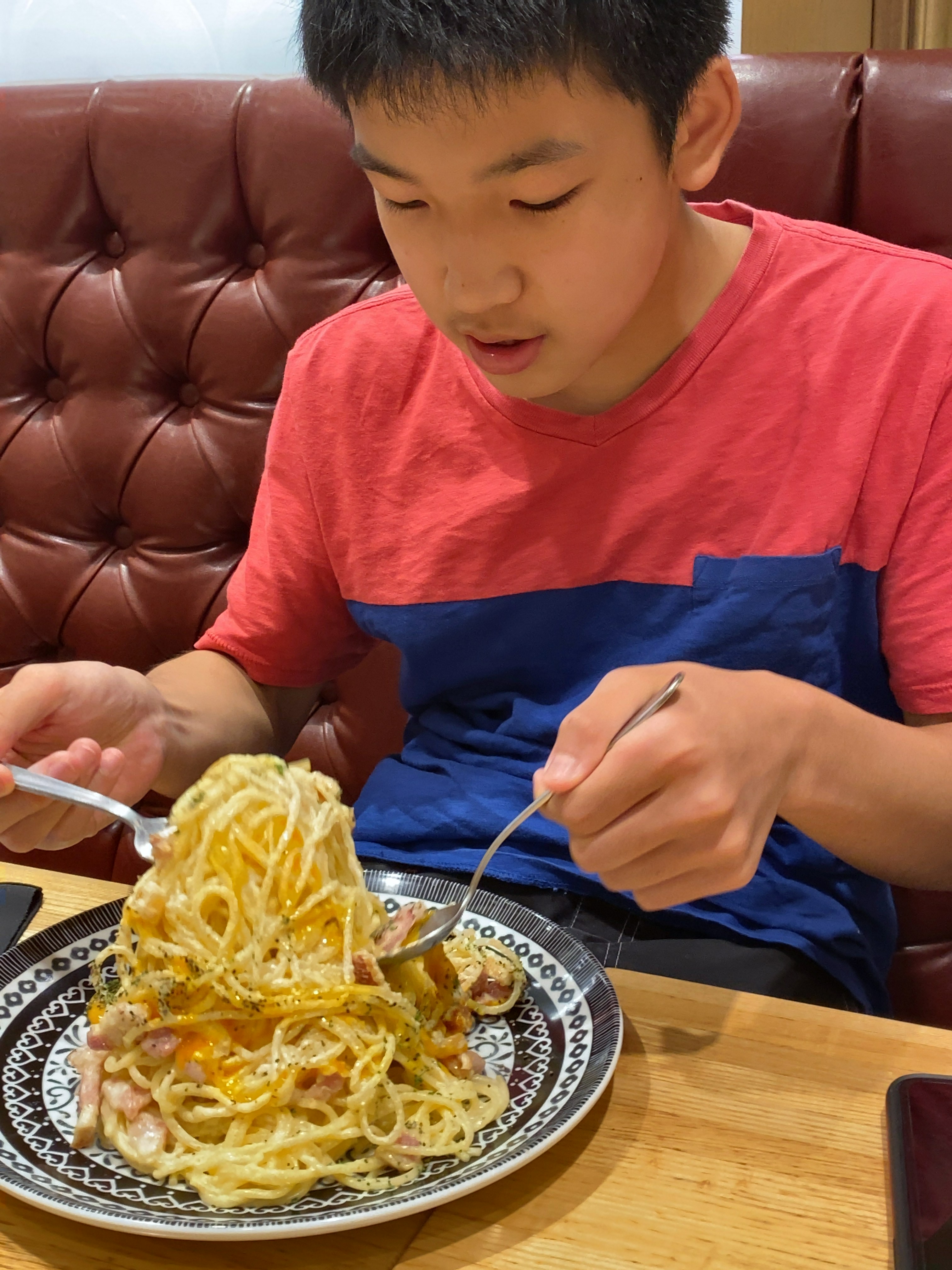 パスタを両手で持ち上げるこども